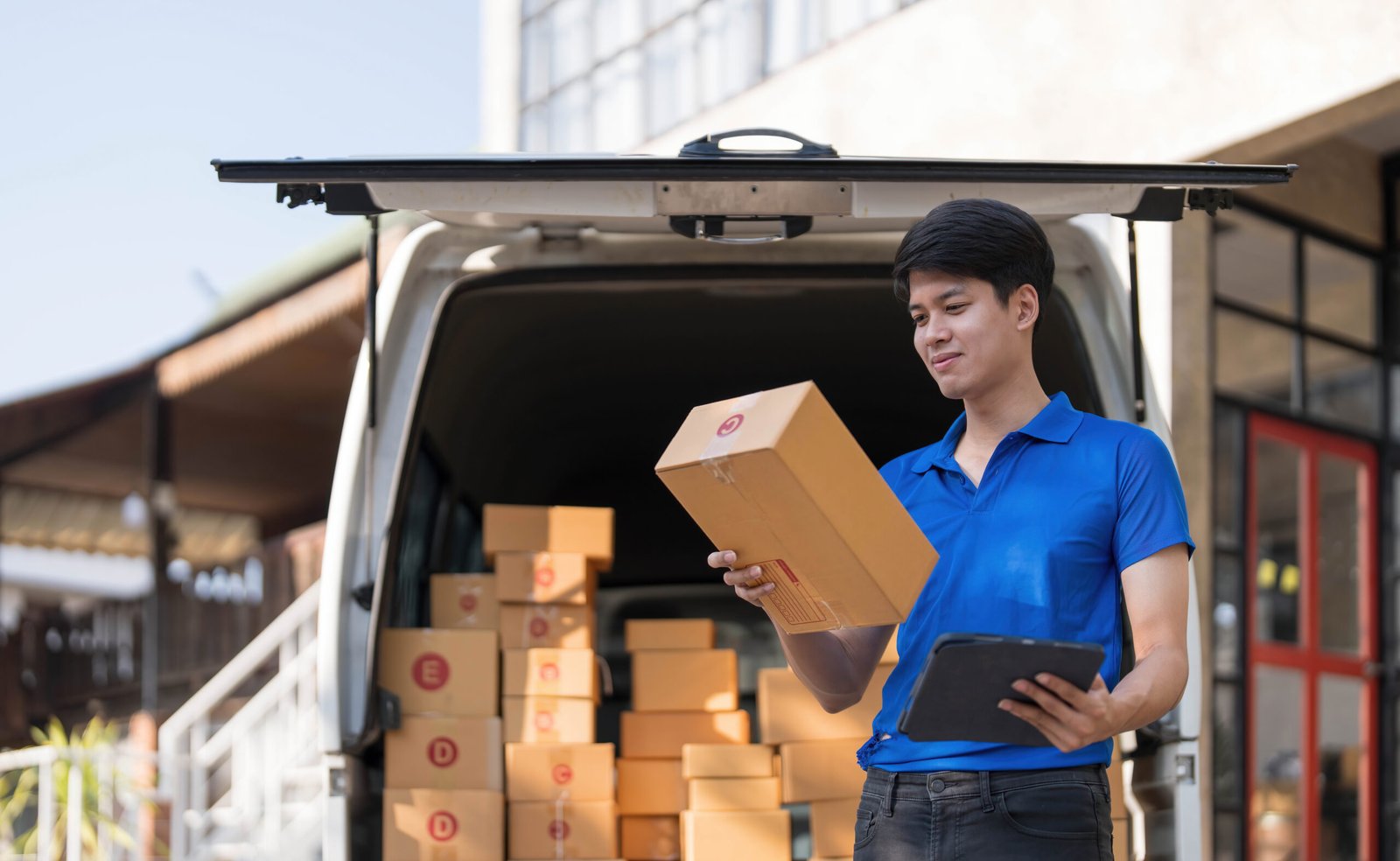 Asian courier with parcel and delivery logistic concept. Delivery man with checking list on clipboard..